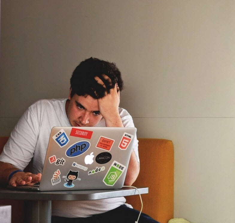 a guy sitting by the computer with the regret on his face, clearly he has no trading plan