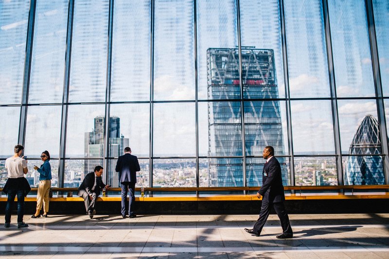 A global macro hedge fund manager is walking towards his investment clients.