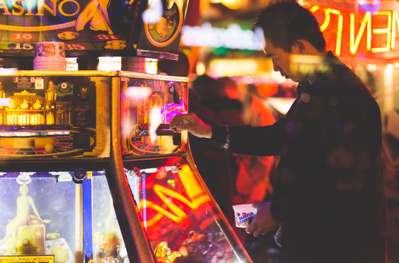 gambling man at the slots machines with day trading red flags in his mind