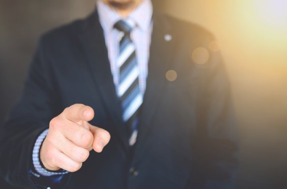 man in a suit with pointing finger that represents the concept of how to make money in Fx trading