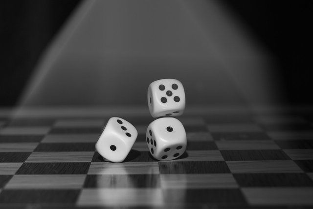 three dices on a chess board representing the Randomness In The Financial Markets