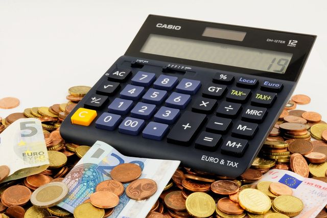 Calculator, pennies and paper money all representing how to trade forex with a small account.