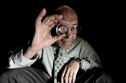 A man with magnifying glass looking for forex technical analysis timeframe.
