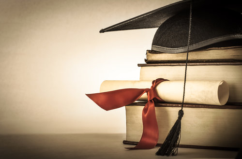 some books and a graduation hat for a successful hedge fund career path