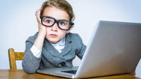 young kid by the laptop thinking about his future hedge fund career path